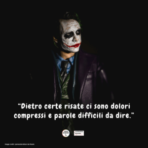 Immagine di un uomo truccato da Joker, in primo piano su sfondo scuro, con espressione intensa e ambigua.
